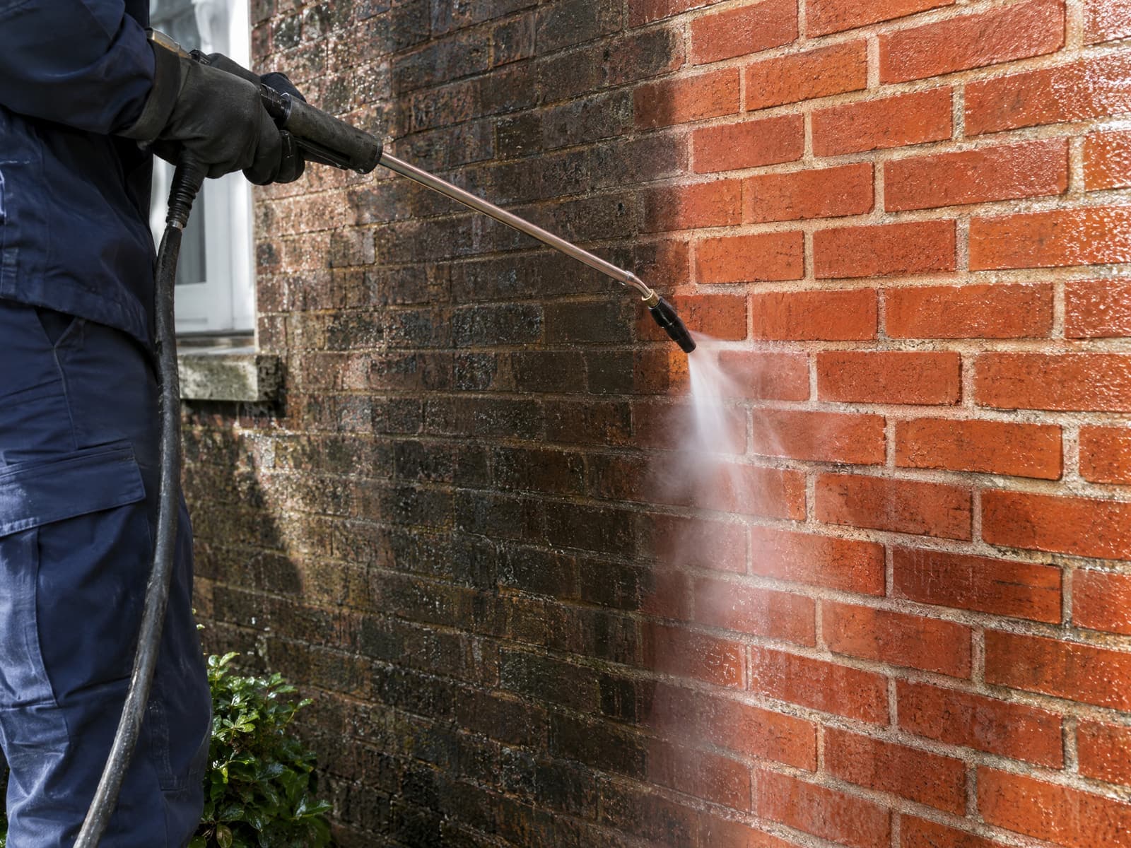 Klinkerfassade wird schonend mit Dampf gereinigt, deutlicher sauberer Streifen