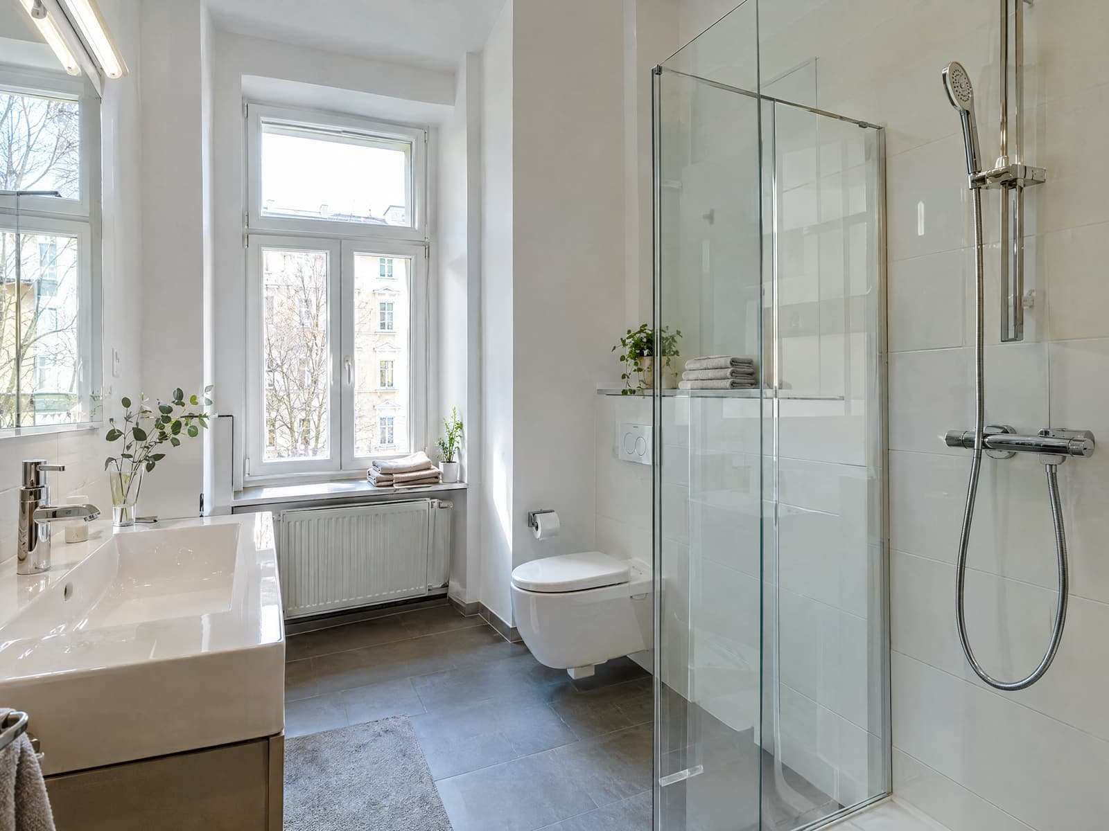 Frisch gereinigtes Badezimmer einer Berliner Wohnung mit glänzender Glasdusche